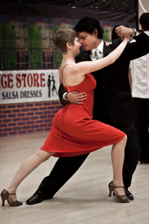 two people in ballroom style dresses dance with each other