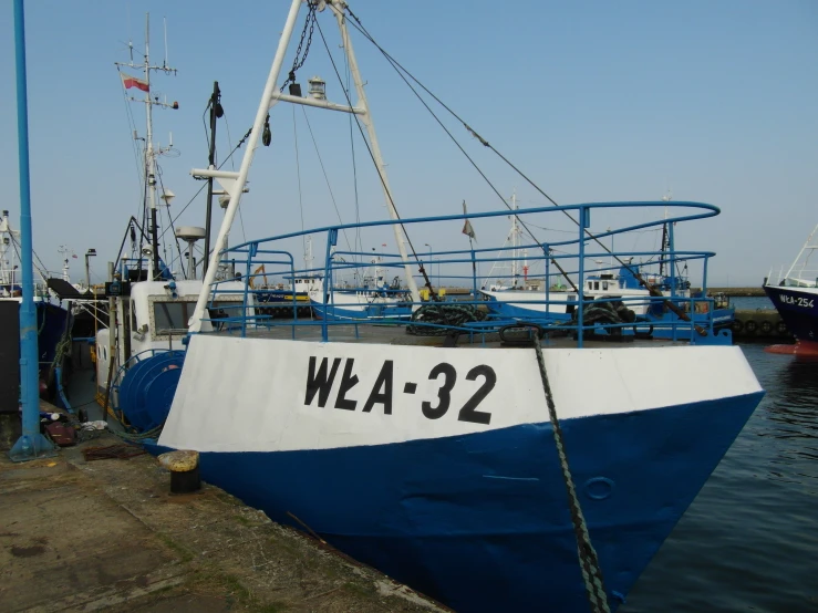 a large white and blue boat tied to a dock