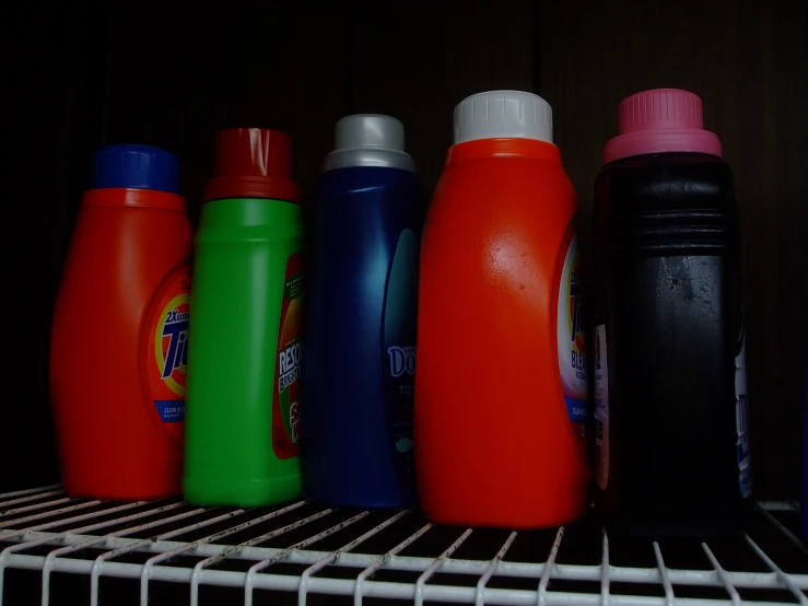 there are six different colored bottles that have lids on them