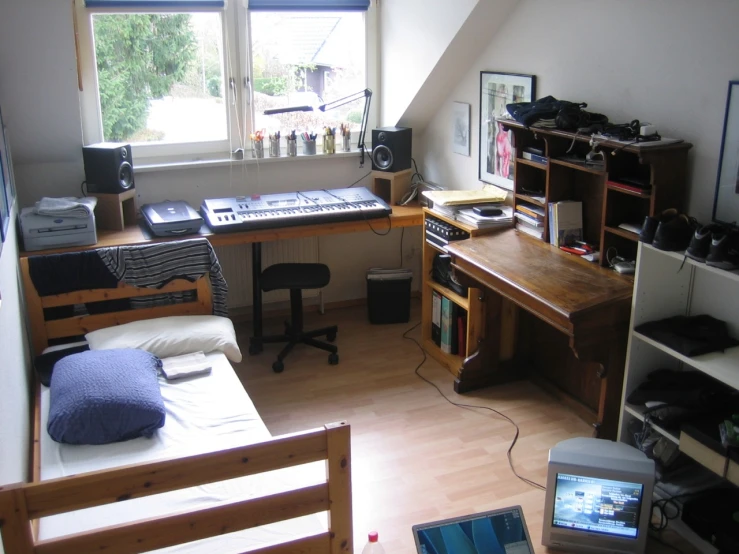 a room that has a bed, desk and shelves in it