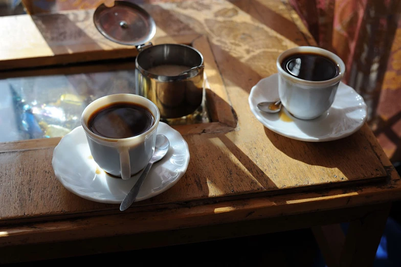 a couple of cups of coffee sit on a table