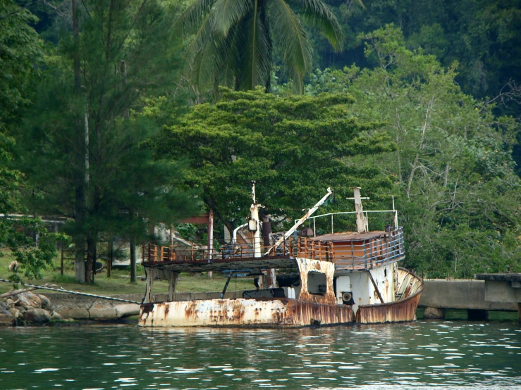 a rusted boat in the water on a lake