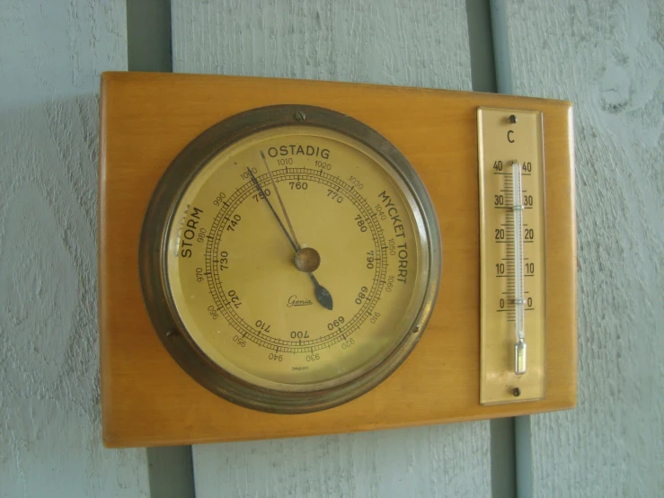 an old fashioned weather gauge is next to a thermometer