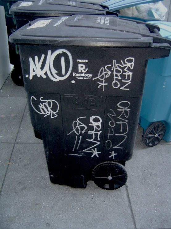 trash can with various graffiti on it outside