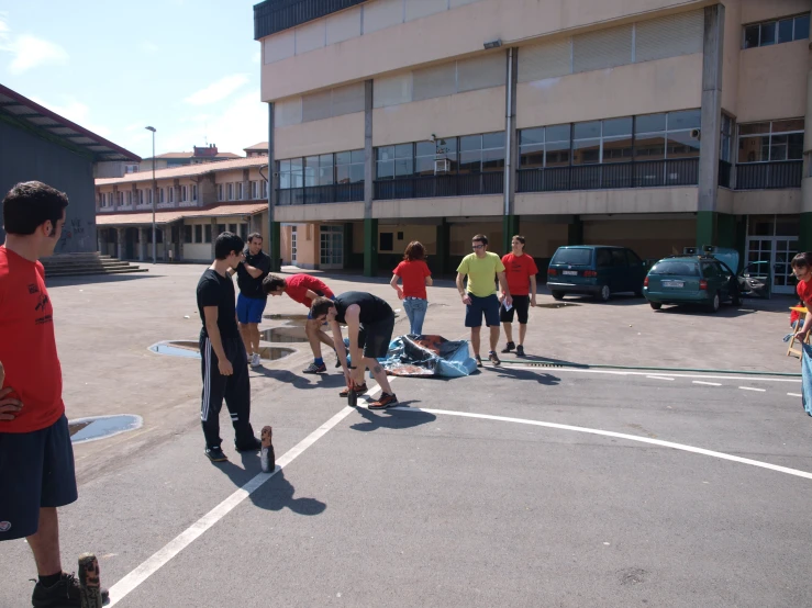 several guys standing in an empty parking lot