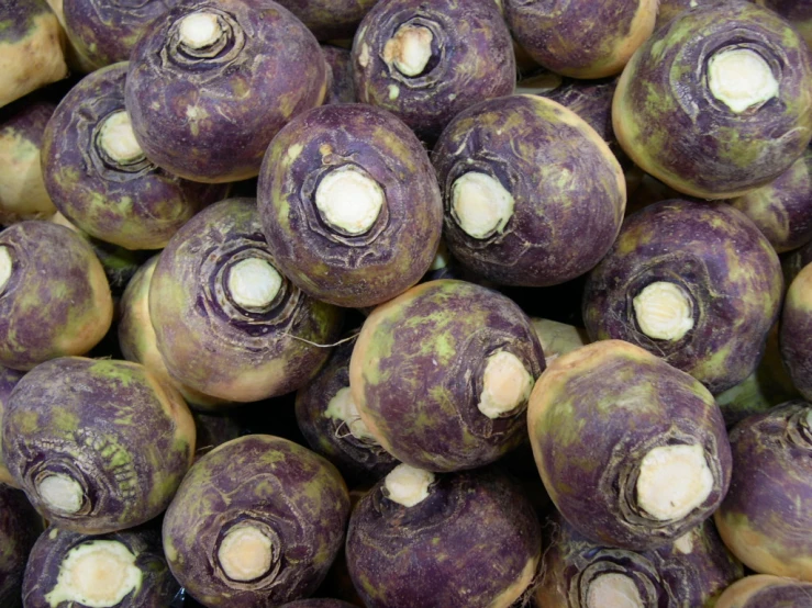 purple fruit is stacked up close to the camera