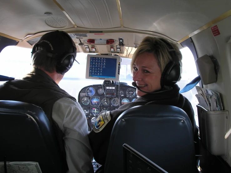 there are two people sitting in the front row of an airplane