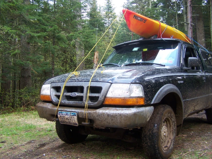 a truck parked on a trail with a kayak on top
