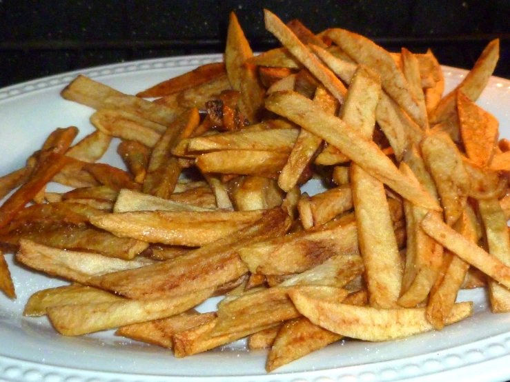 french fries are piled on a plate on the table