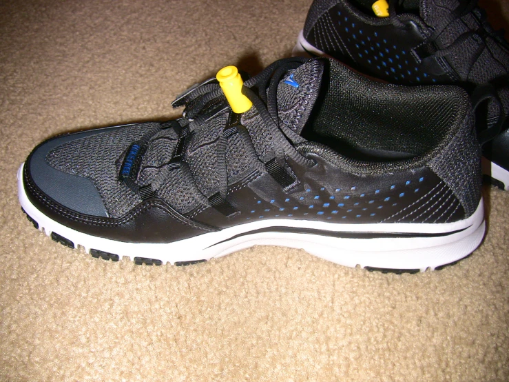 the shoe laces are attached to a black pair of shoes