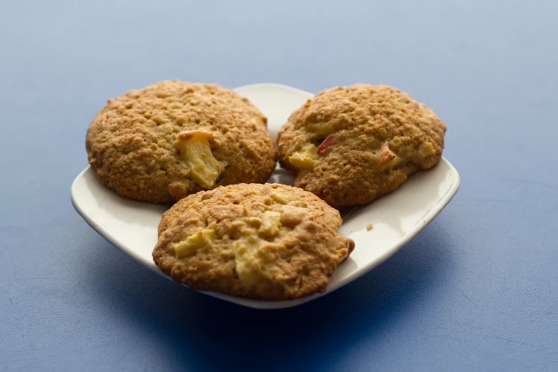 four cookies on a plate sitting on a table