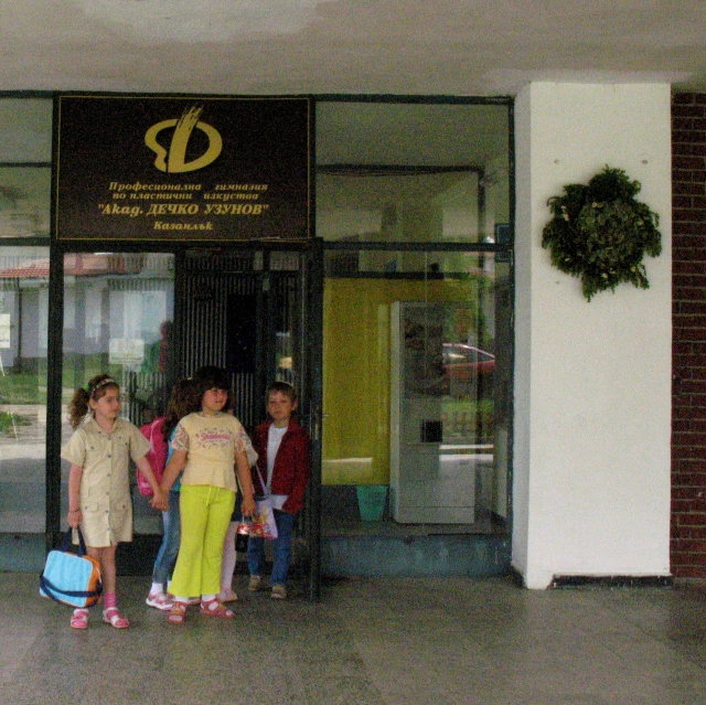 a group of people stand outside of the entrance of a building