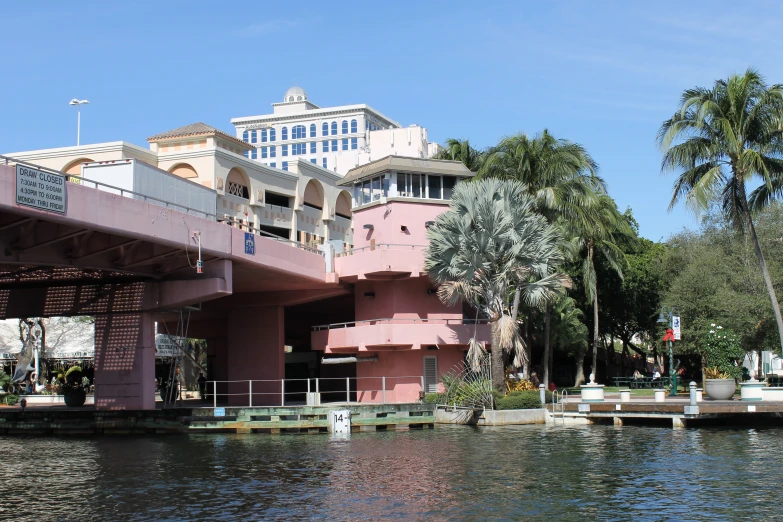 there is a boat going down the river past a building