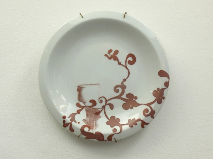 a plate with a flower design hanging on the wall