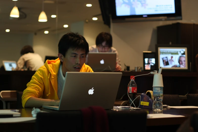 a man is using his laptop and sitting at the table