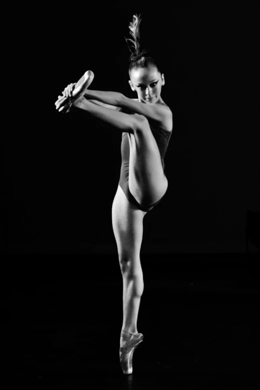 a woman wearing a ballet leotard in the dark