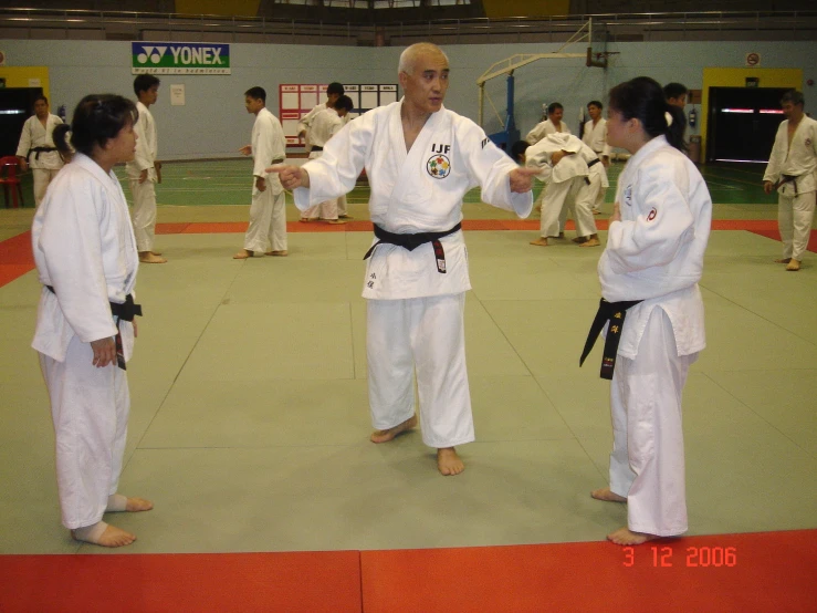 a group of men standing around each other on a karate court