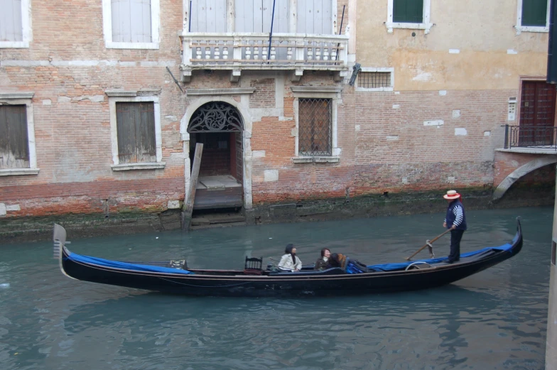 a man on a gondola floating down the middle of a river