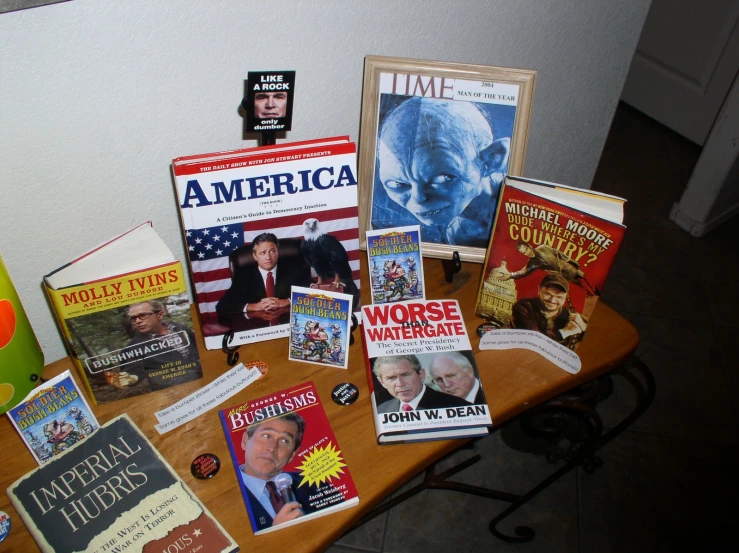 books stacked on a wooden table together and magazine covers