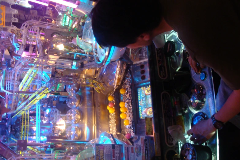 the man is observing inside the pinball machine