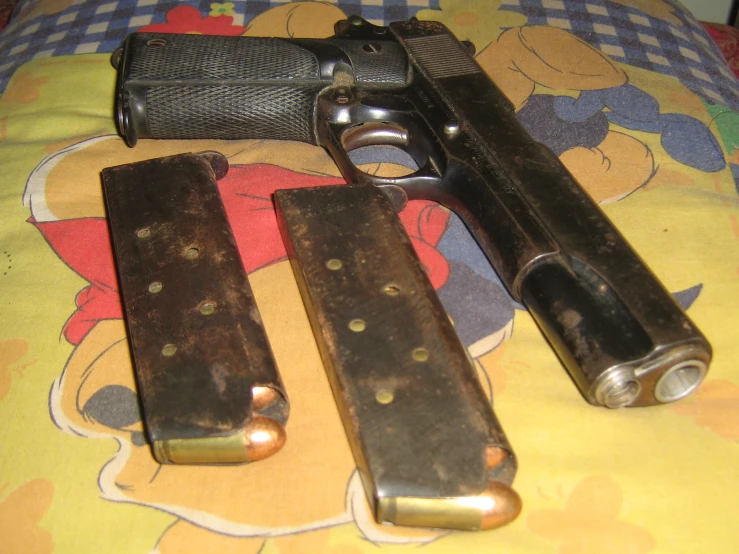 two old revolvers are lying on a bed