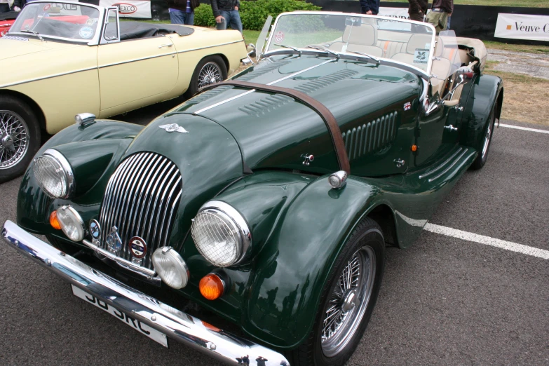 an old green car is parked in the lot