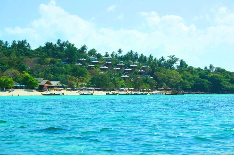 the blue water and tropical landscape with umbrellas