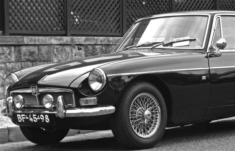 a black vintage car parked on the side of a street