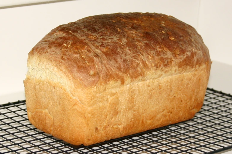 an uncooked loaf of bread sitting on top of a cooling rack