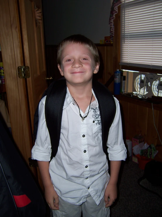 a little boy that is wearing a vest