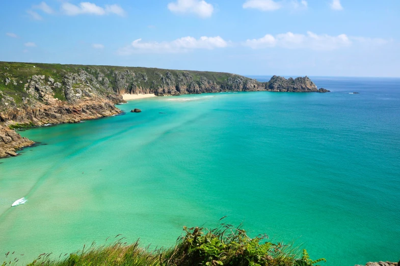 the beach and cliff are next to the sea