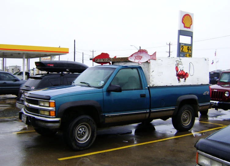 a truck is sitting in the parking lot of a gas station