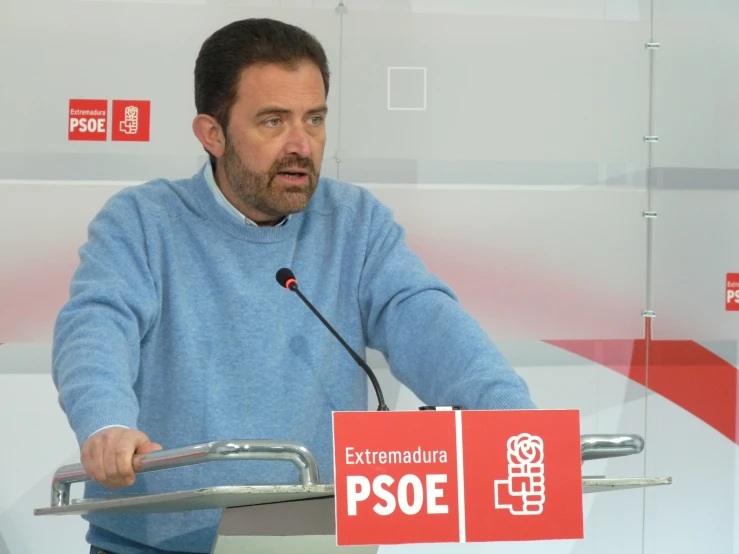 a man speaking at a podium while holding a microphone