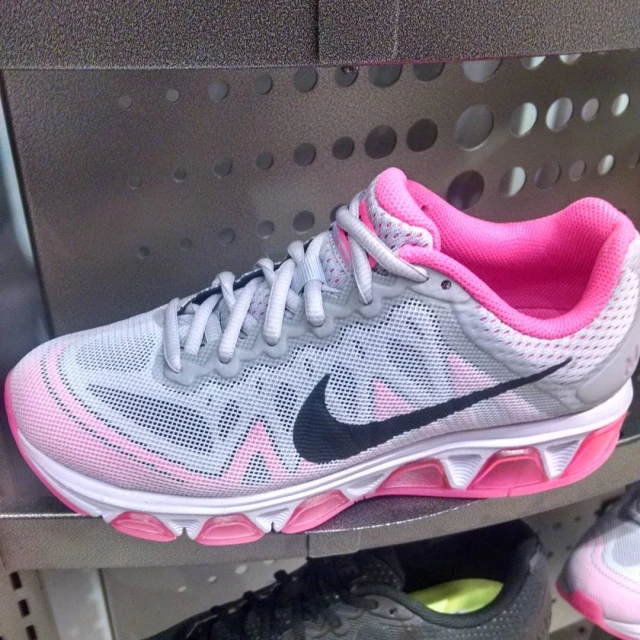 a women's nike sneak with pink and white accents