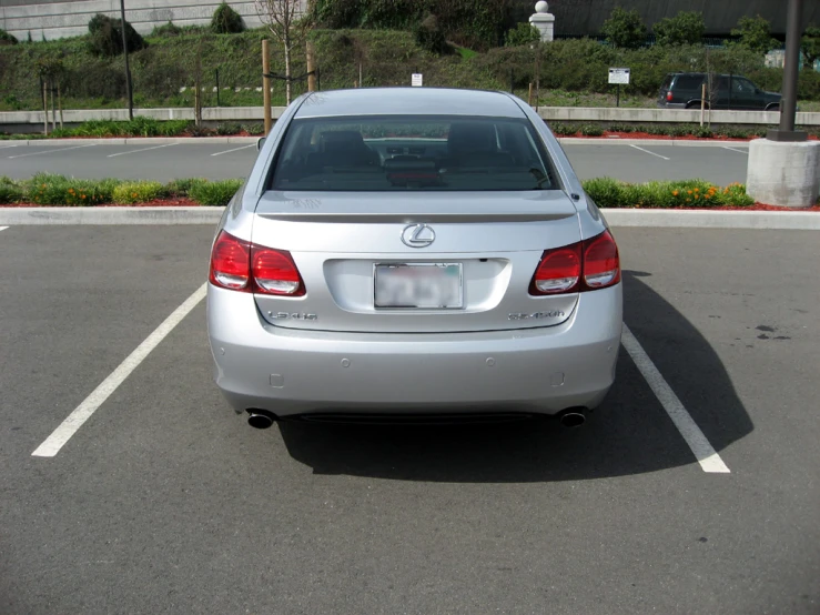 a silver vehicle parked in a parking lot with a green fire hydrant