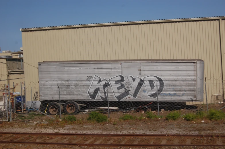 a truck is parked on the side of the track near some graffiti