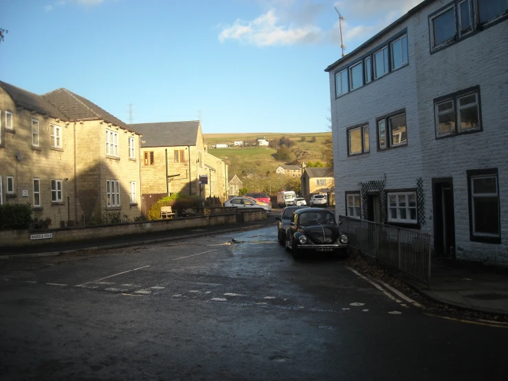 a small black car is parked on a road