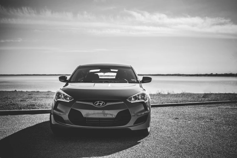 a car parked in a road next to a body of water