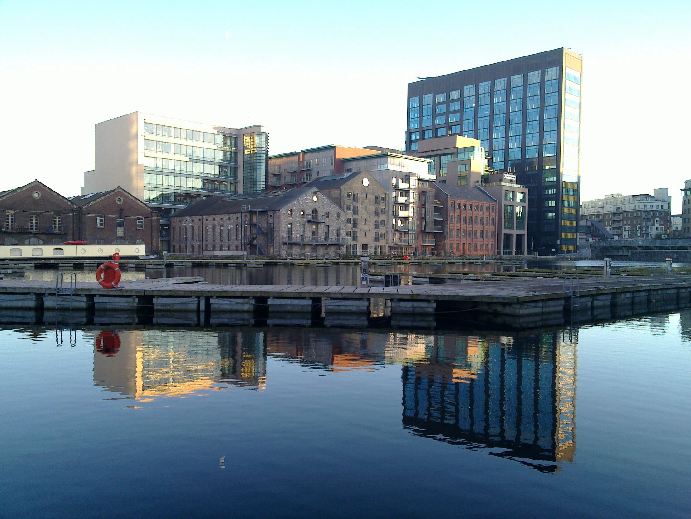 some buildings a large body of water and a stop sign