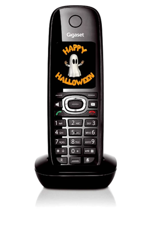 a cellphone sitting on a stand with halloween designs on it