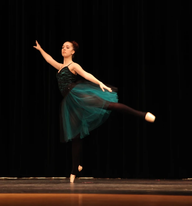 a woman in a green dress on a stage