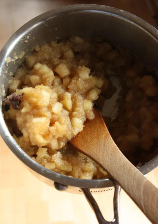 a wooden spoon in a saucepan with food