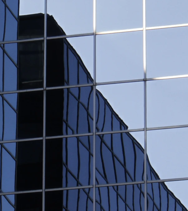 reflection of an airplane in a glass building