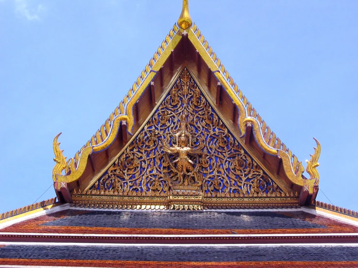 the intricate roof of a temple against a blue sky