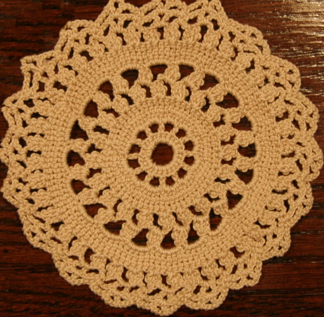 a large beige doily sitting on top of a wooden table
