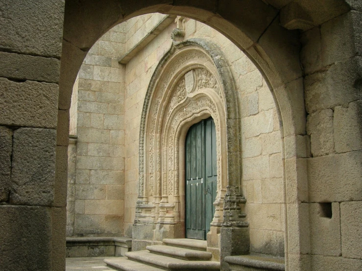 a stone entrance leading into a hallway with a green door