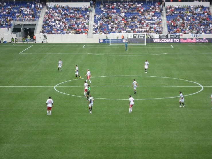 many people in a soccer field playing with a ball