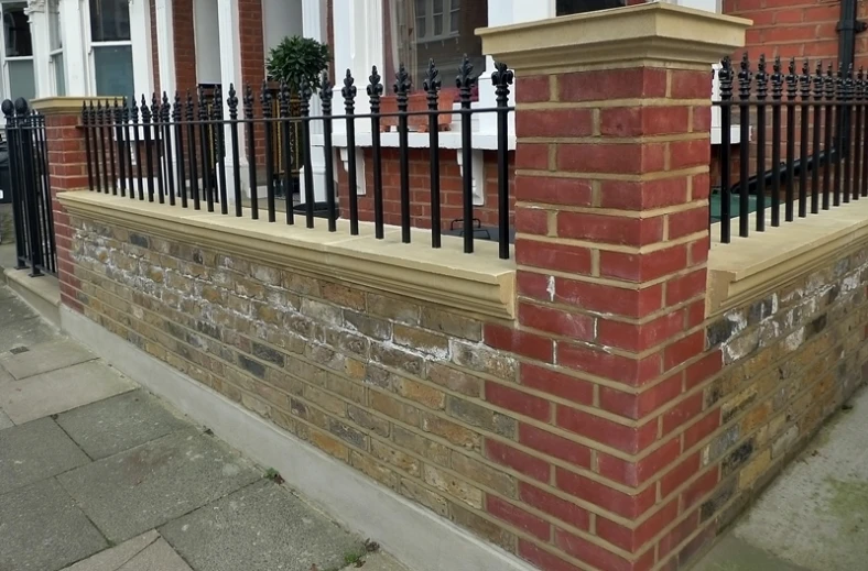 a small red brick building with a black iron railing