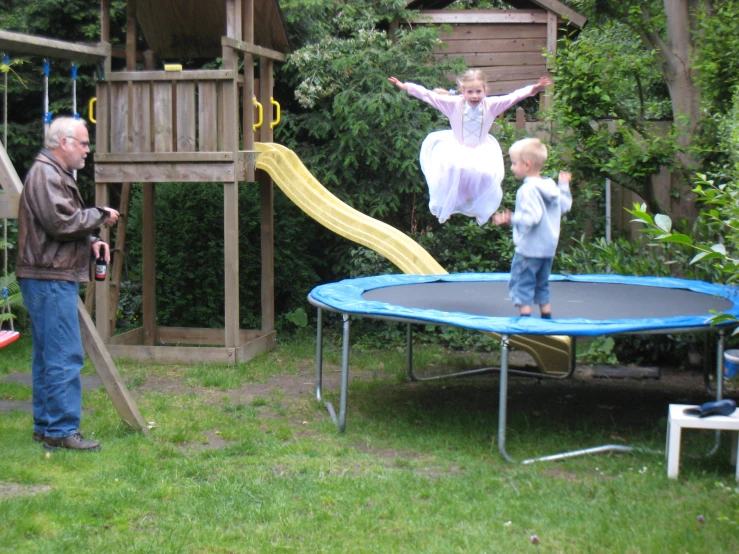 a man and a little girl on top of a trampoline