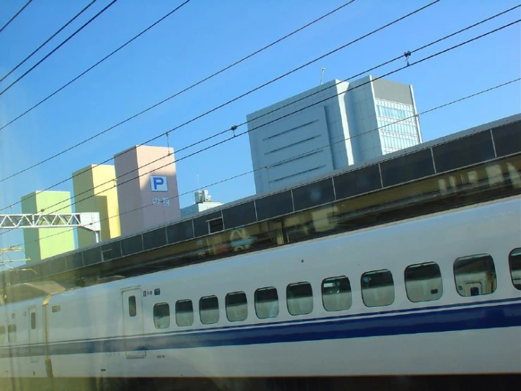 there is a commuter train on the tracks near tall buildings